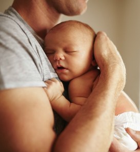 Tender moment between a father and newborn baby boy