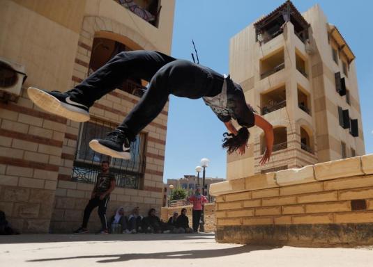 Mariam Emad from Parkour Egypt "PKE" practices her parkour skills around buildings on the outskirts of Cairo